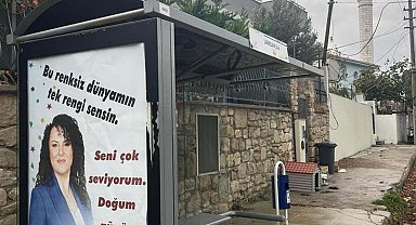 Eşinin doğum gününü otobüs duraklarına astırdığı afişlerle kutladı